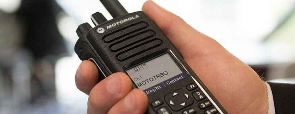 Rádio HT profissional em ambiente de montagem industrial